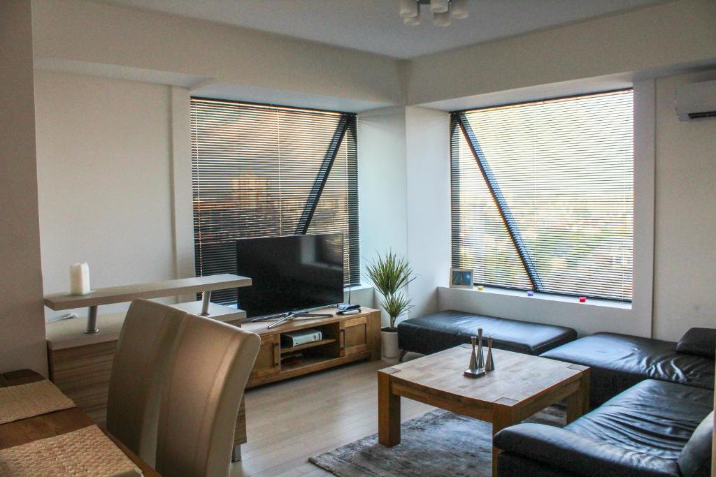 a living room with a couch and a tv at High End Apartments in Diamond Garden Building in Skopje