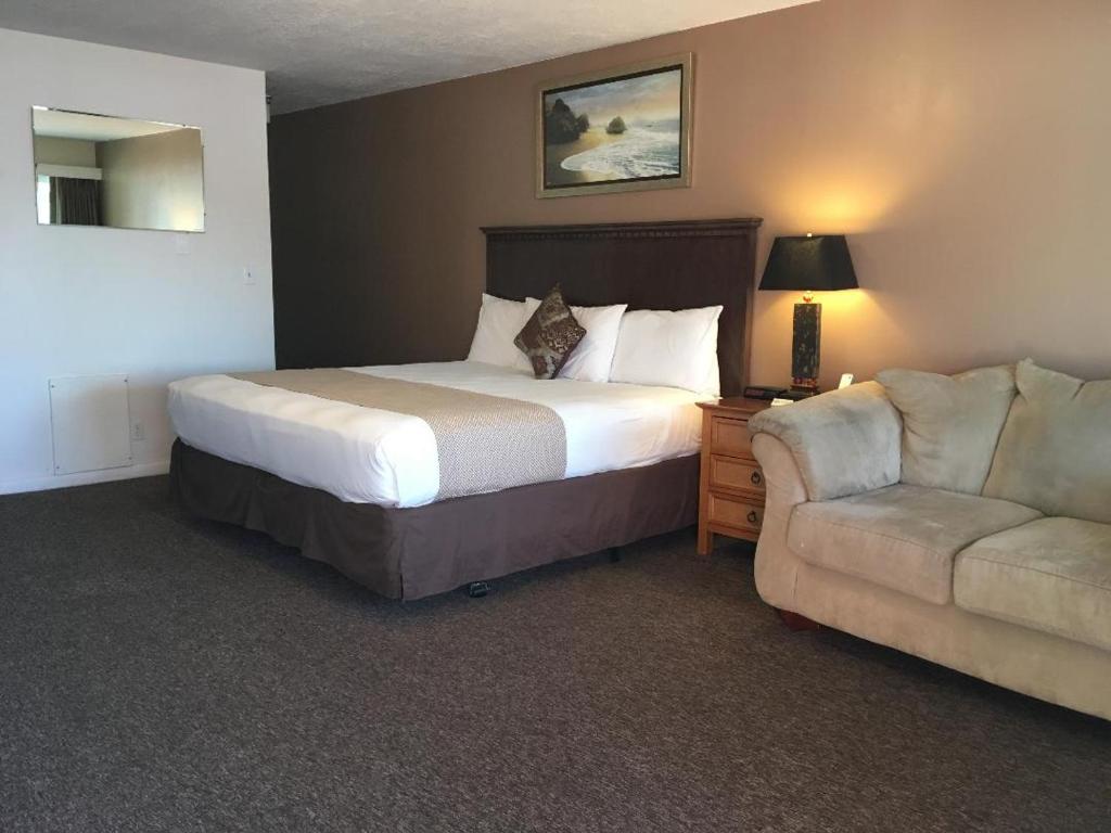 Habitación de hotel con cama y sofá en Rest Assured Inns & Suites, en Montpelier