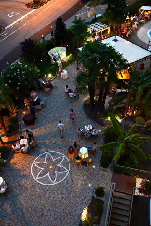 widok na dziedziniec z osobami siedzącymi przy stolikach w obiekcie Palace Hotel Città w Arco