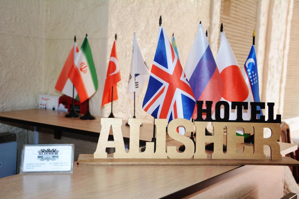 a wooden sign with flags on top of a table at Alisher B&B Hotel in Samarkand