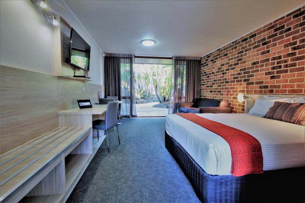 a hotel room with a bed and a tv at Beenleigh Yatala Motor Inn in Yatala