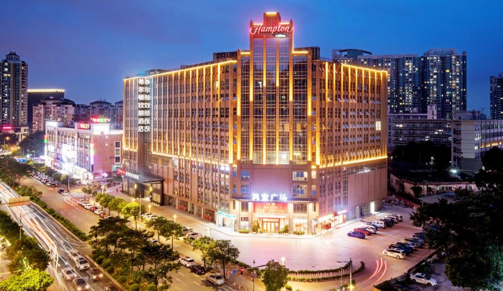 un edificio illuminato in una città di notte di Hampton by Hilton Guangzhou Dongxiaonan a Canton