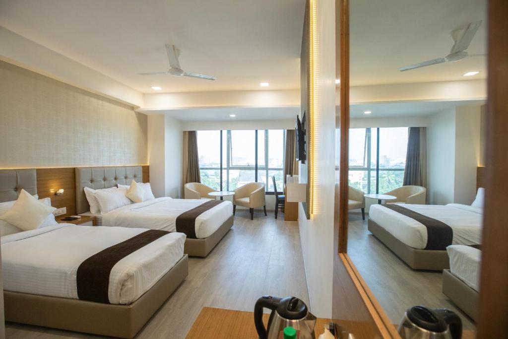 a hotel room with two beds and a living room at Hotel Grace Galaxy in Mumbai