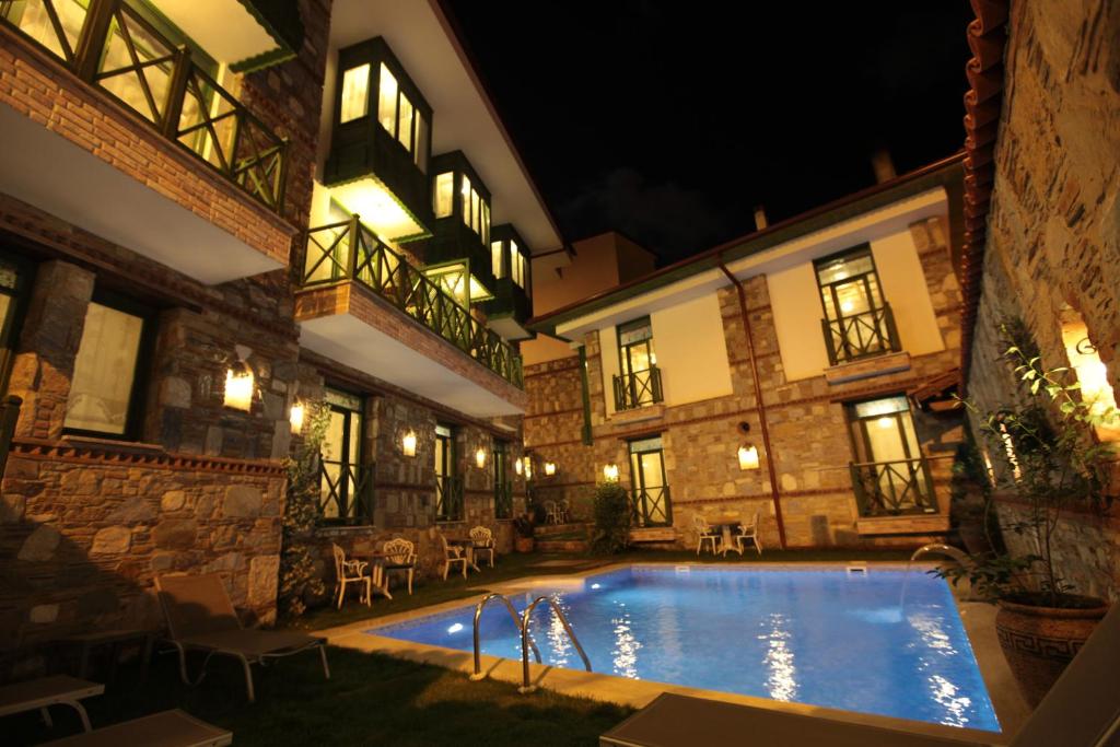 a pool in the courtyard of a building at night at Celsus Boutique Hotel in Selcuk