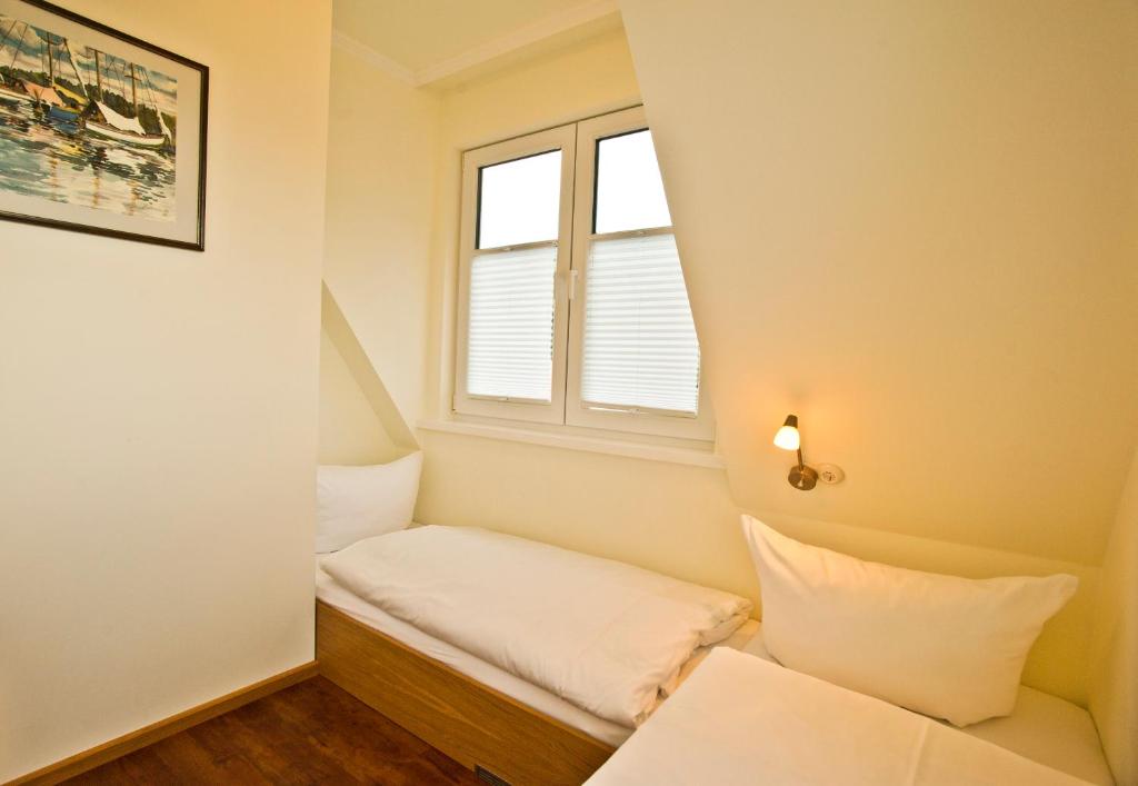 Habitación pequeña con cama y ventana en Ferienhäuser Südwind, en Hiddensee