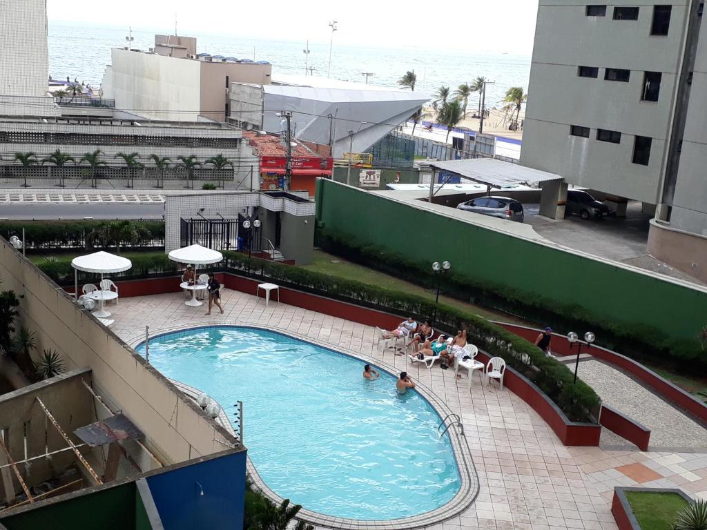 a large swimming pool with people sitting around it at Residence Porto de Iracema in Fortaleza