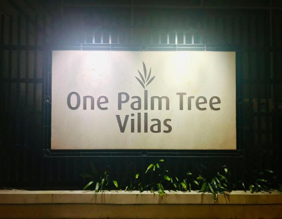 a sign that reads one palm tree villas at One Palm Tree Villas across NAIA-T3 in Manila