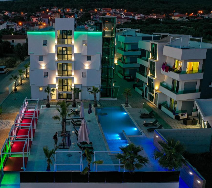 un edificio de apartamentos con piscina por la noche en Boutique Residence Cosmopolis, en Bibinje
