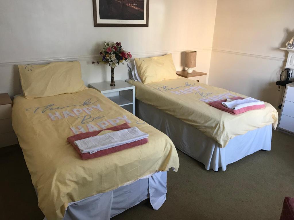 two beds in a room with towels and flowers at Double J8 m27 in Southampton
