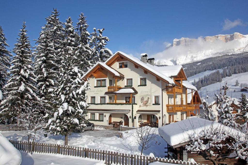 una casa en la nieve con una valla en Apartments Lasteis, en La Villa