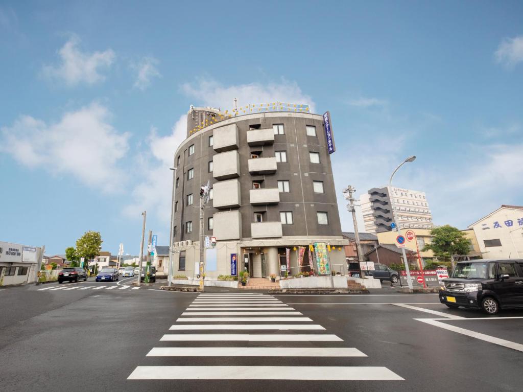 ein Gebäude in einer Stadtstraße mit einem Fußweg in der Unterkunft Tabist Asa Station Hotel 