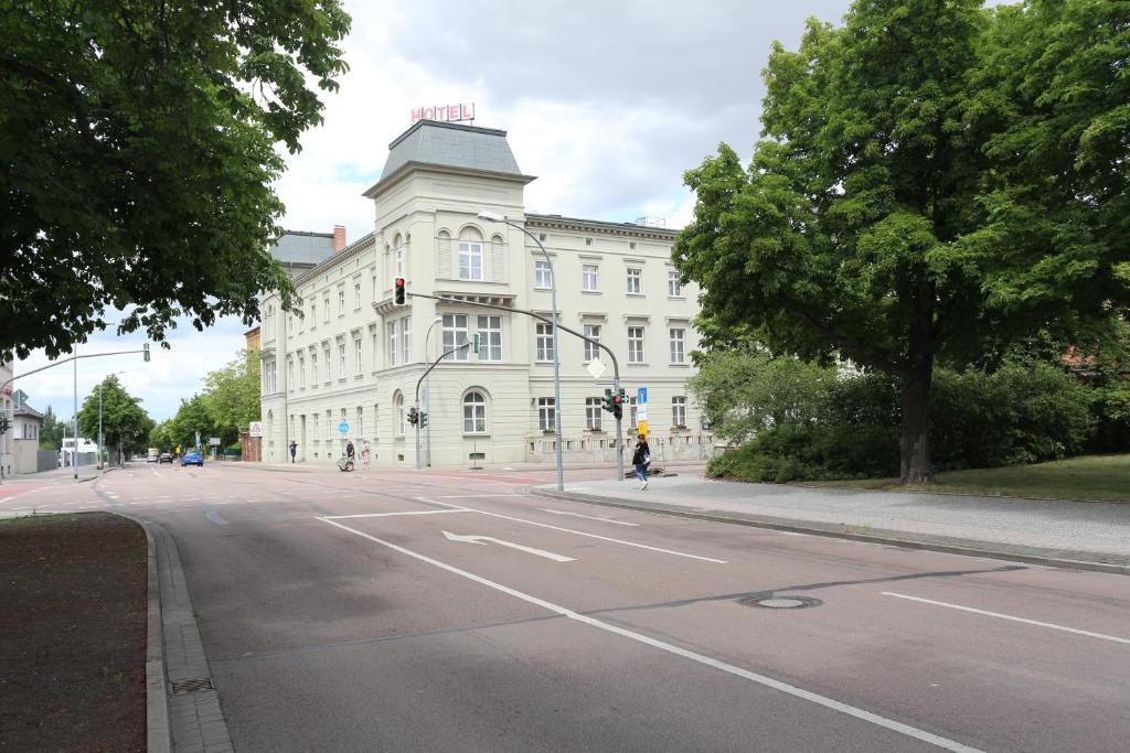 克騰的住宿－Hotel "Stadt Köthen"，前面有一条街道的白色大建筑