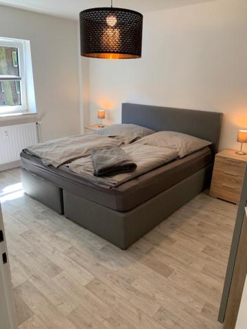 a bed sitting in a bedroom with a lamp at FeWo in Sterkrade in Oberhausen
