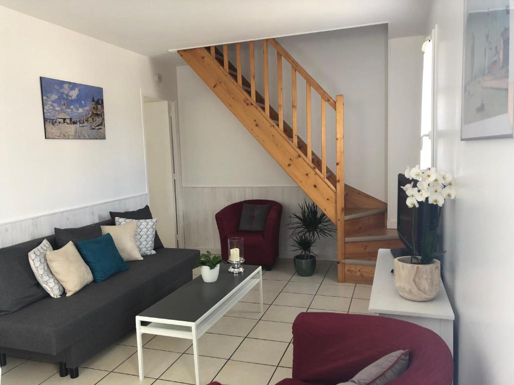 a living room with a couch and a staircase at La terrasse honfleuraise in Honfleur