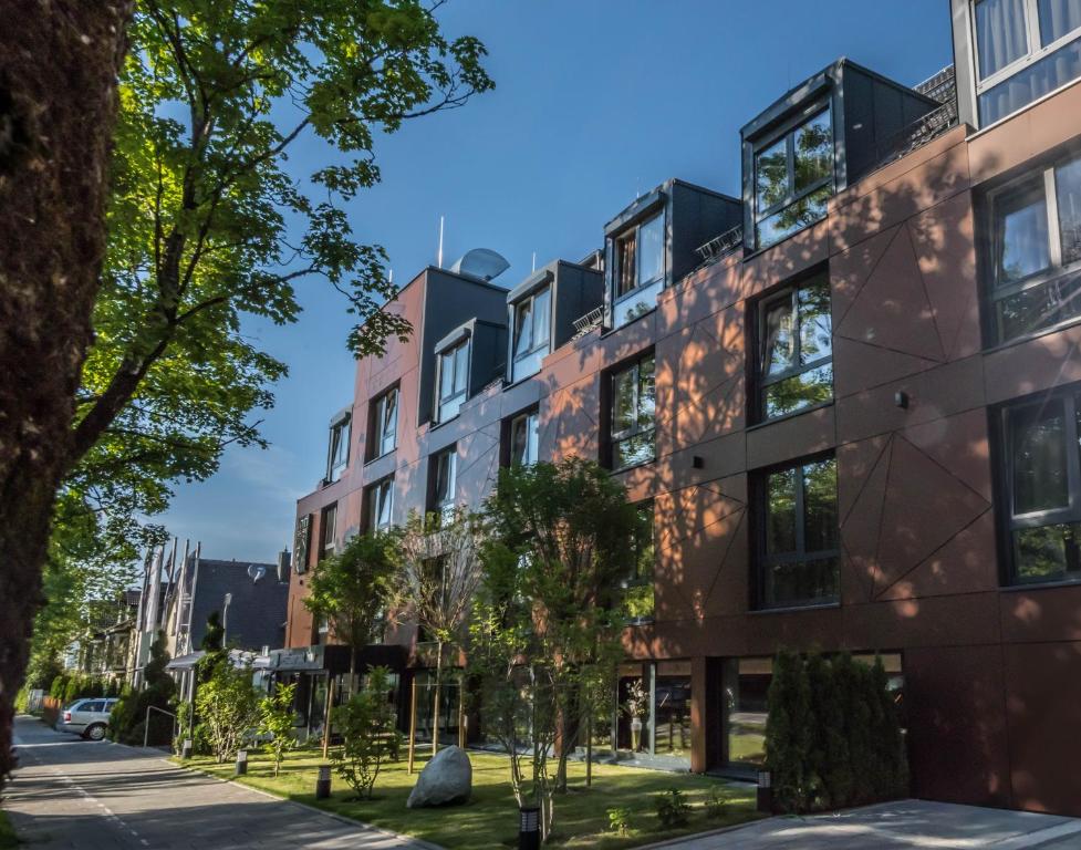 an apartment building on a street with trees at Innspire Hotel in Munich