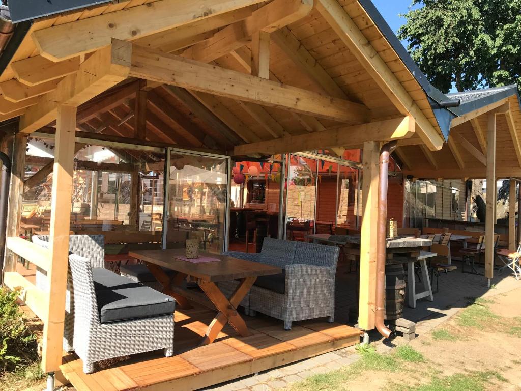 a wooden pergola with a wooden table and chairs at Carolinger Hüttendorf in Weyer