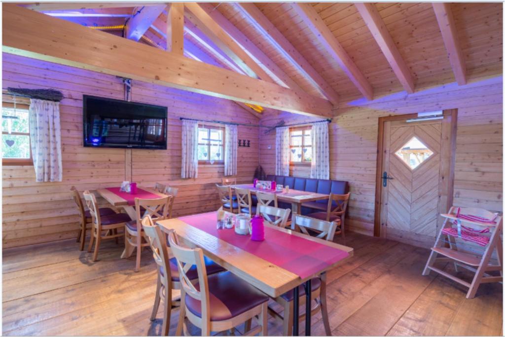 a dining room with tables and chairs in a cabin at Carolinger Hüttendorf in Weyer