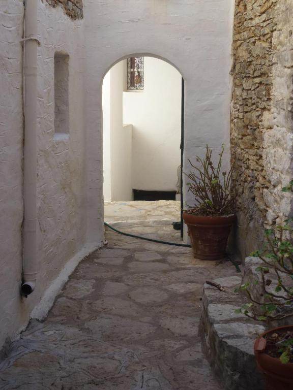an alley with an archway in a building with a mirror at Villa Sofia in Symi