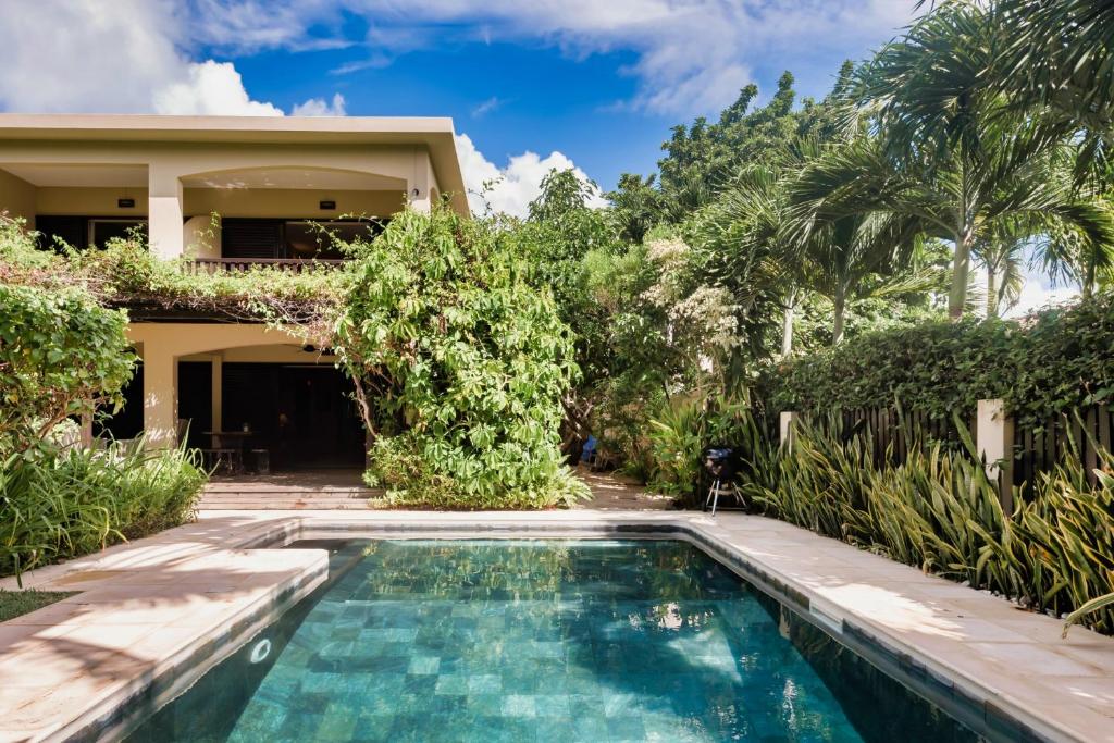 a villa with a swimming pool in front of a house at Villa Vakoa - Tranquil Villa With Lush Gardens in Pointe d'Esny