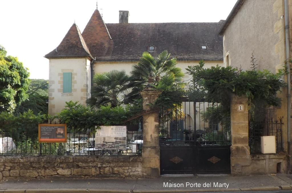 dom z bramą z kutego żelaza i ogrodzeniem w obiekcie Maison Porte del Marty w mieście Lalinde
