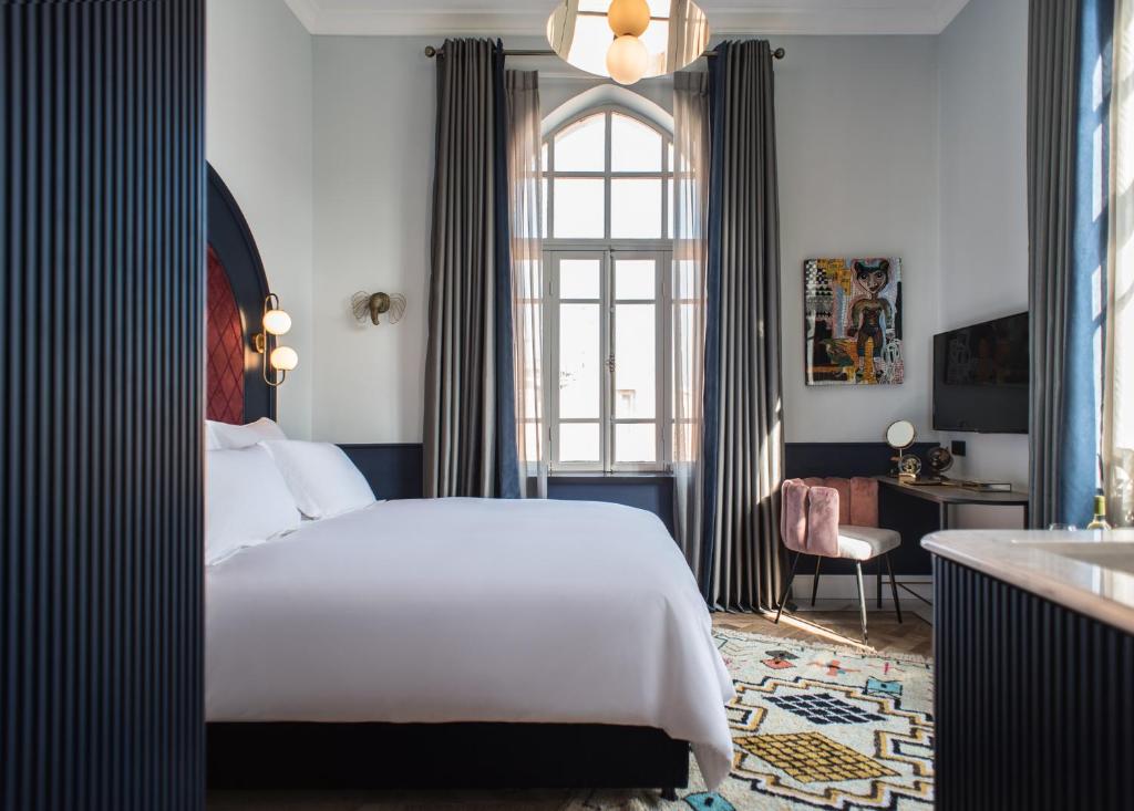 a bedroom with a large bed and a bathroom at Elmina Hotel Jaffa in Tel Aviv