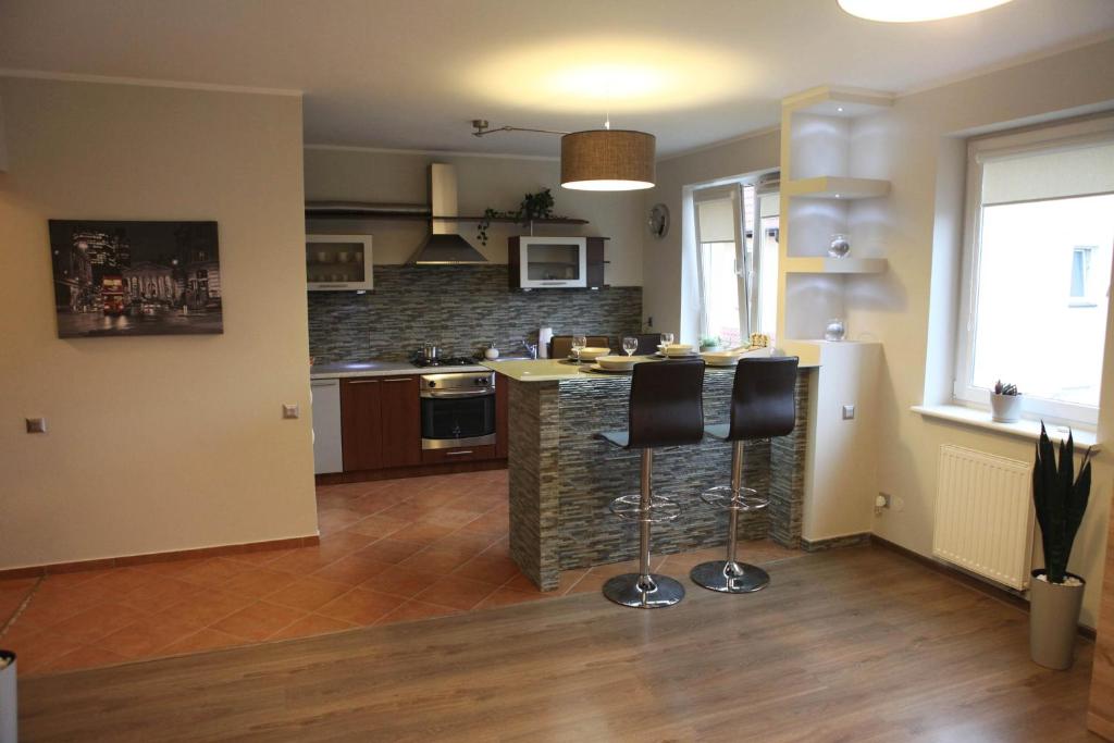 uma cozinha com um balcão e dois bancos de bar em Apartament-Studio em Szczecin