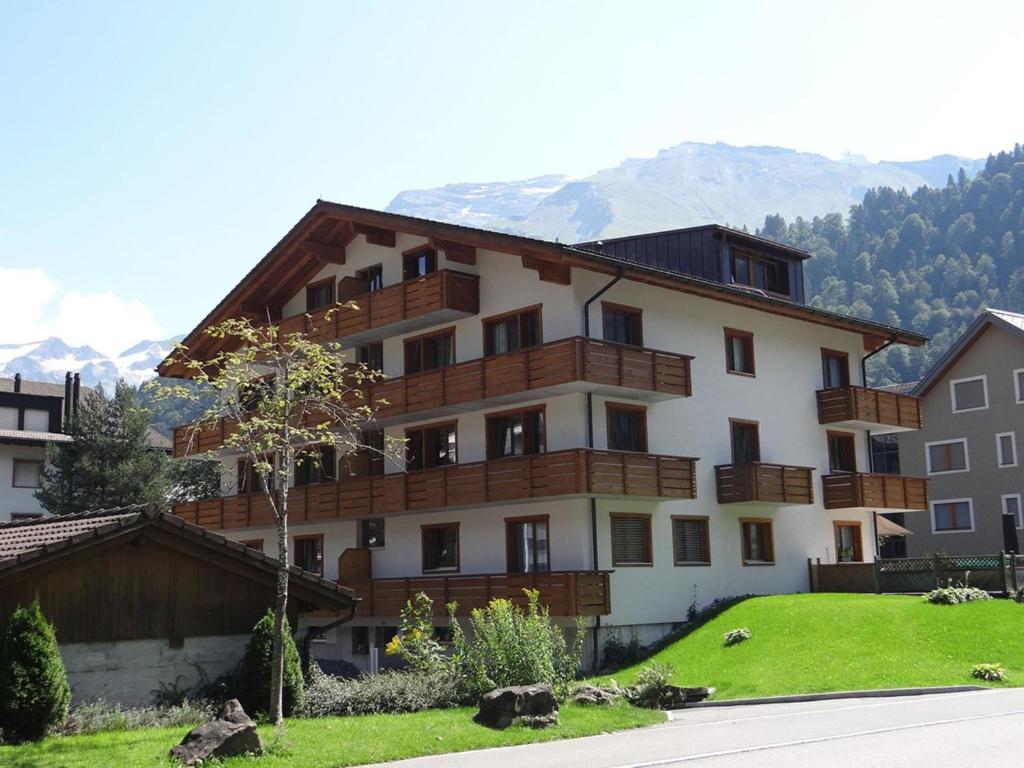 a large apartment building with a green lawn in front of it at Apartment Alpenstrasse 1 by Interhome in Engelberg