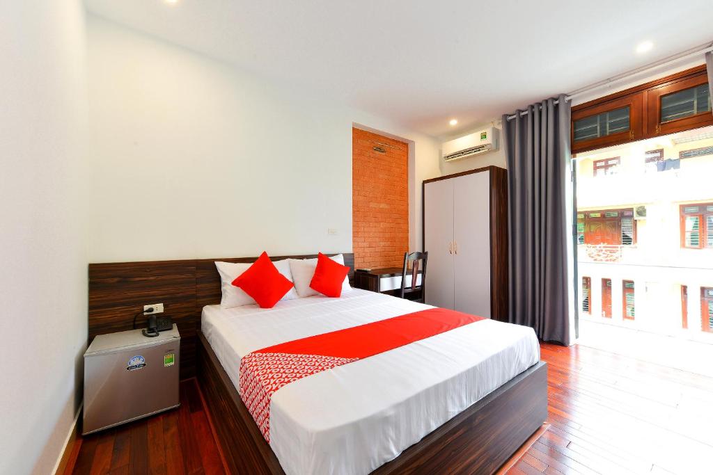 a bedroom with a large bed with red pillows at OYO 317 Kim Cuong Hotel 2 in Hanoi
