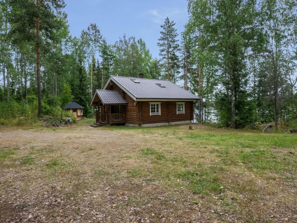 una cabaña de madera en medio de un campo en Holiday Home Neitlinna by Interhome, en Pitkälahti