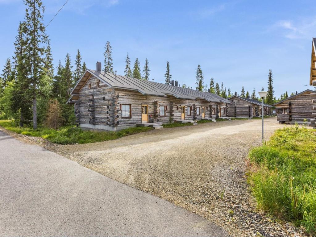 an empty road in front of a log cabin at Holiday Home Sapara c10 by Interhome in Äkäslompolo