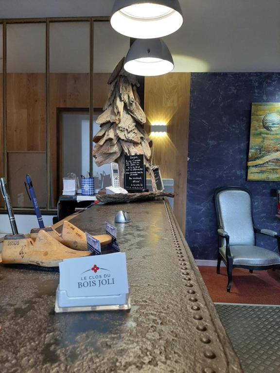 a lobby with a table with a sign on it at Le Clos du Bois Joli in Lagnieu