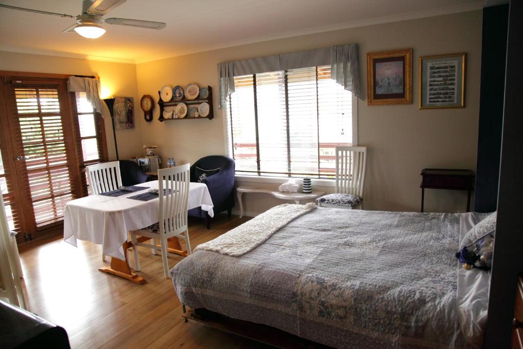 a bedroom with a bed and a table and chairs at Cottage on Main in Franklin