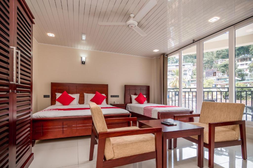 1 dormitorio con 2 camas, mesa y sillas en Janora Hills, en Kandy