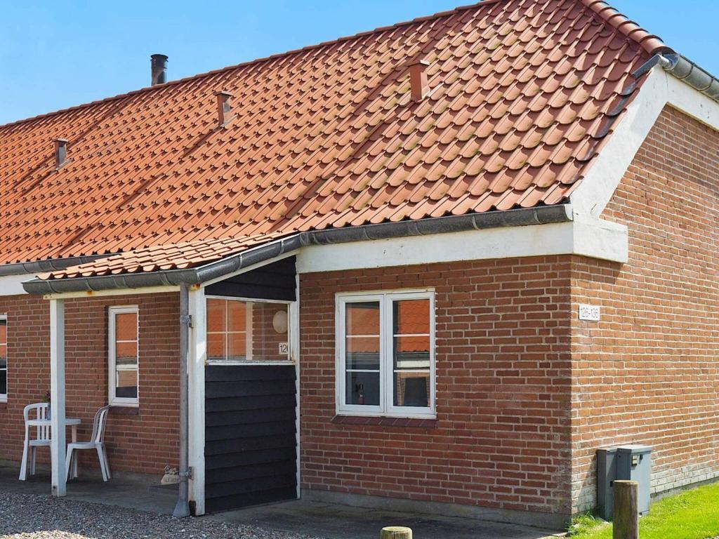 a red brick house with a table and a chair at 6 person holiday home in Lemvig in Lemvig