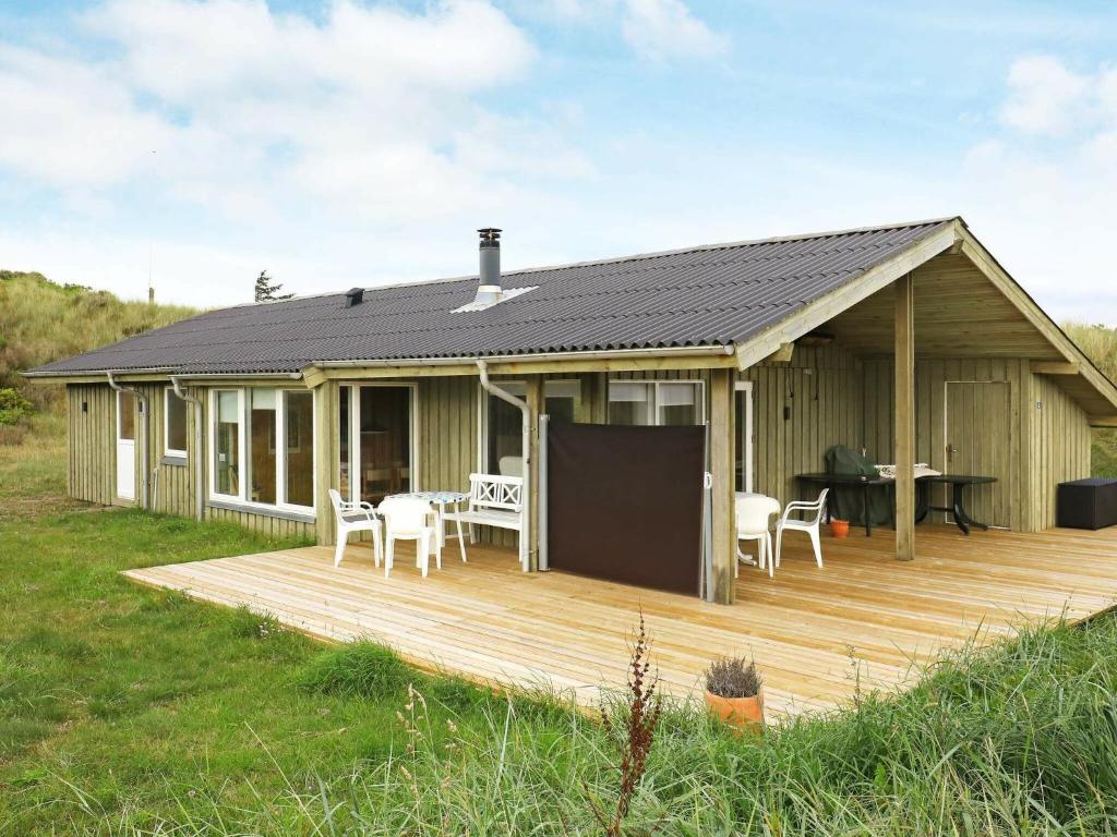 Casa con terraza con mesa y sillas en Holiday home Løkken XLVII, en Løkken