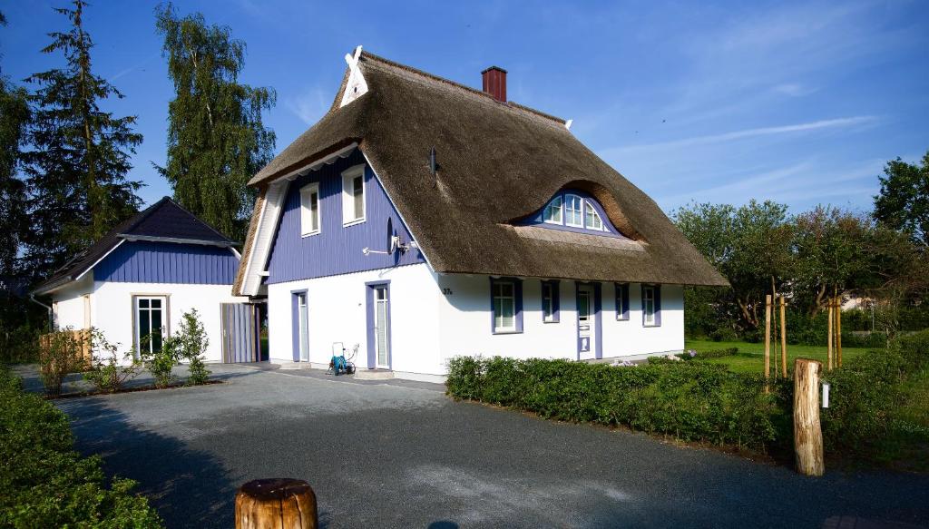 a white house with a thatched roof at Haus Meerblau in Born