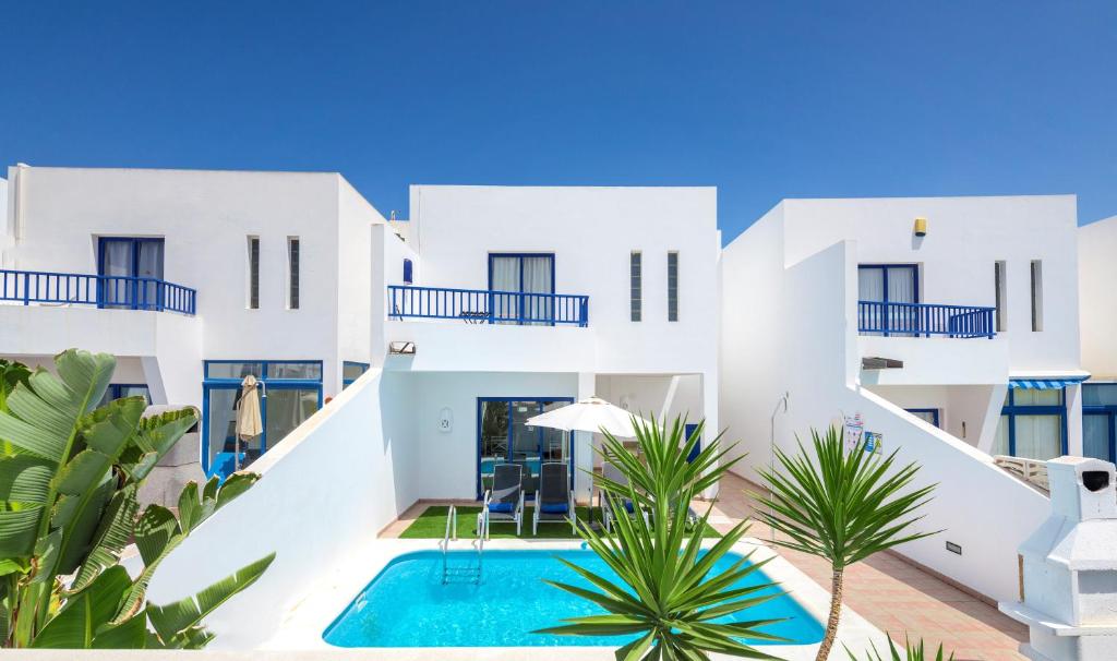 a large white swimming pool in front of a house at Villas Puerto Rubicon in Playa Blanca