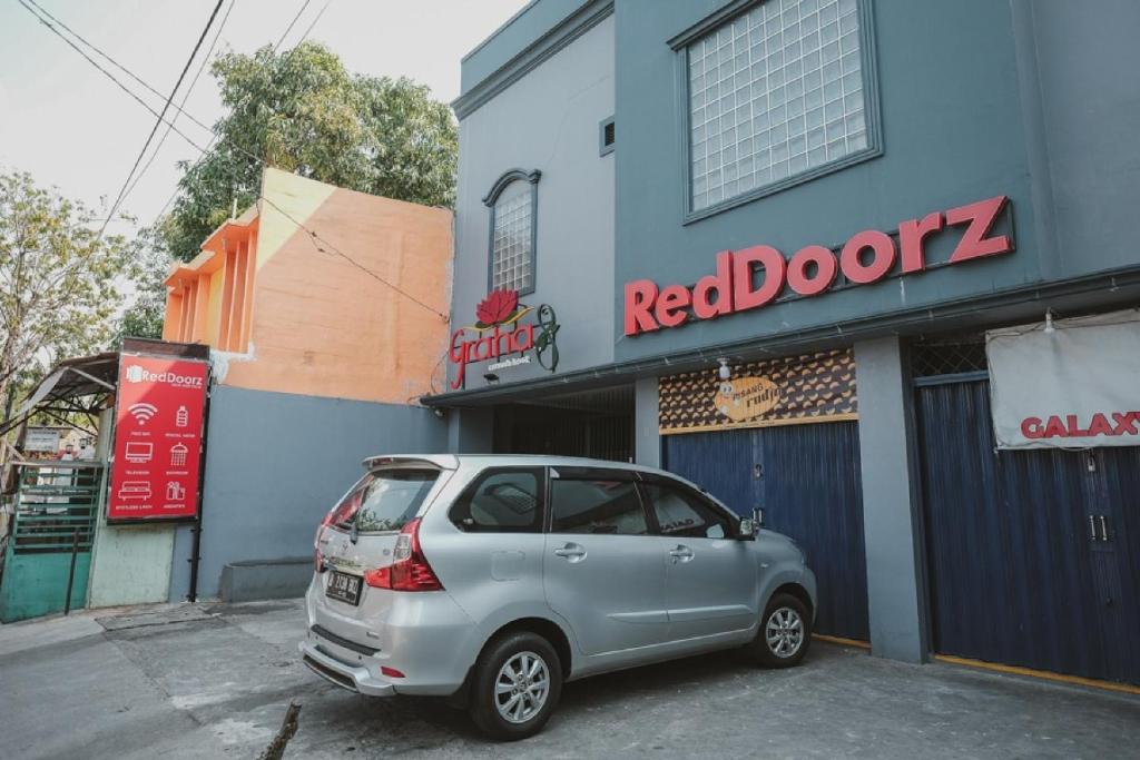 a silver car parked in front of a building at RedDoorz near RSUD Koja in Jakarta