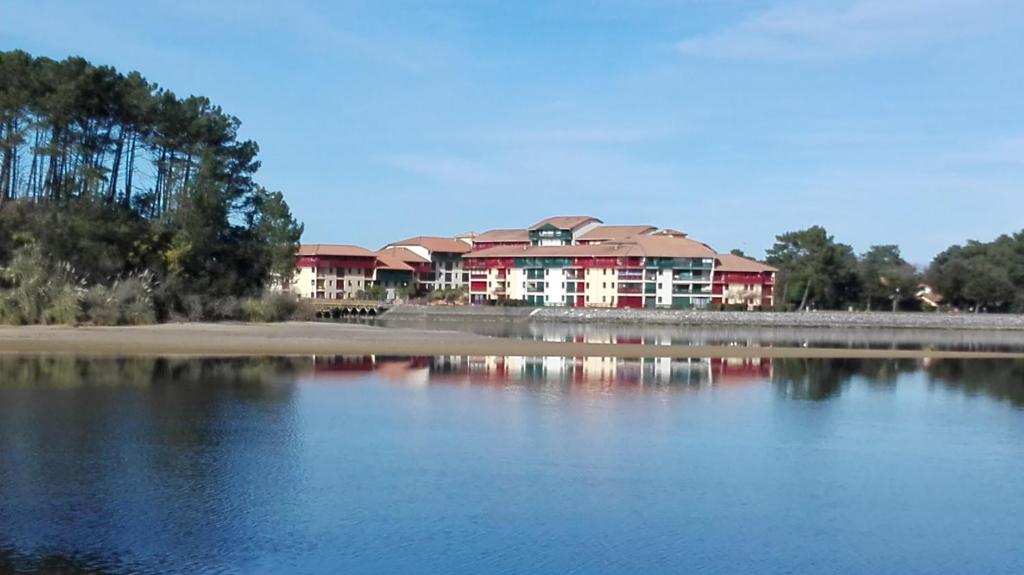 a large red building next to a body of water at appartement T2bis idealement situé au bord du lac marin de Vieux Boucau in Vieux-Boucau-les-Bains