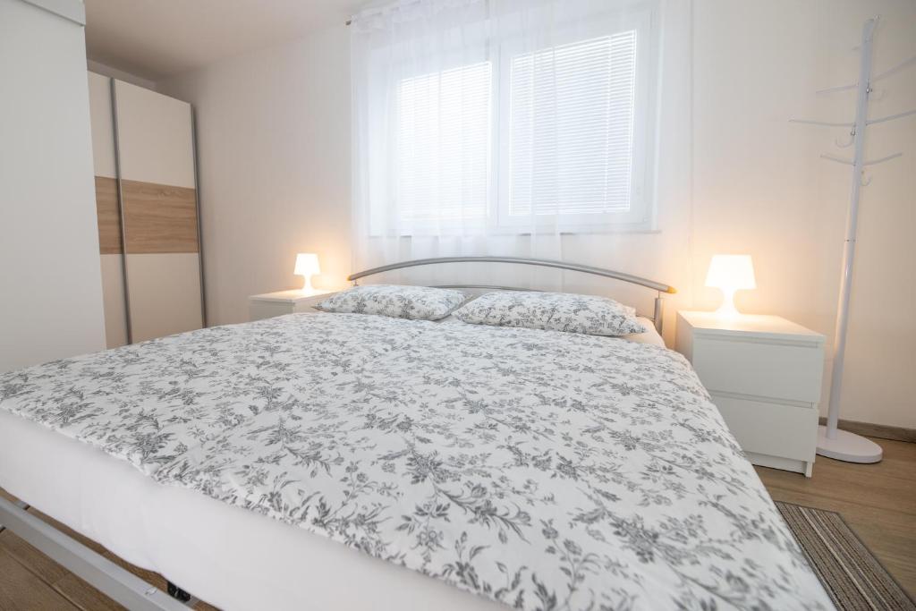 una camera bianca con un letto e due lampade di Sobe Meta a Brezje