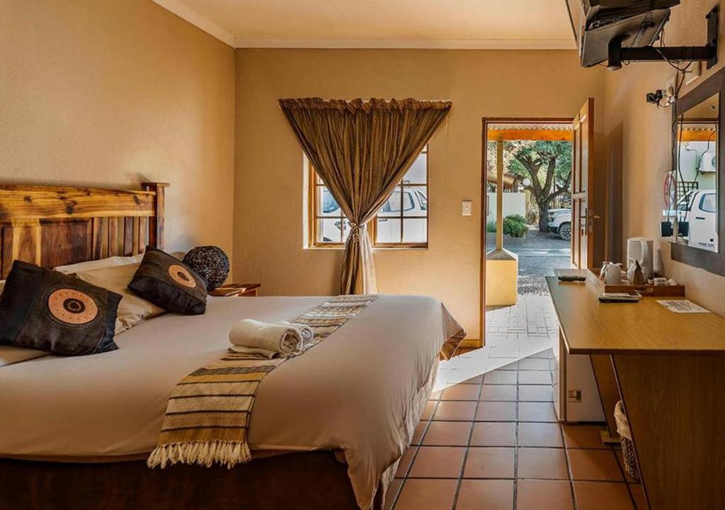 A bed or beds in a room at Kuruman Hotel