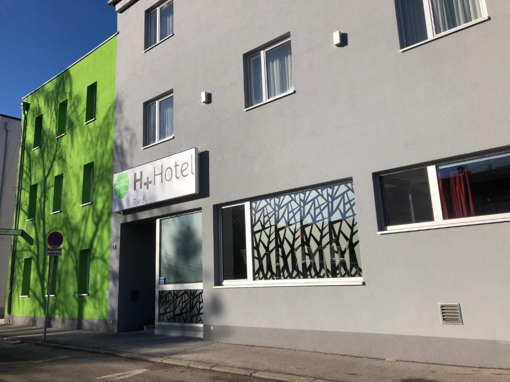 eine Fassade eines Gebäudes mit einem Laden in der Unterkunft H+ Hotel Ried in Ried im Innkreis
