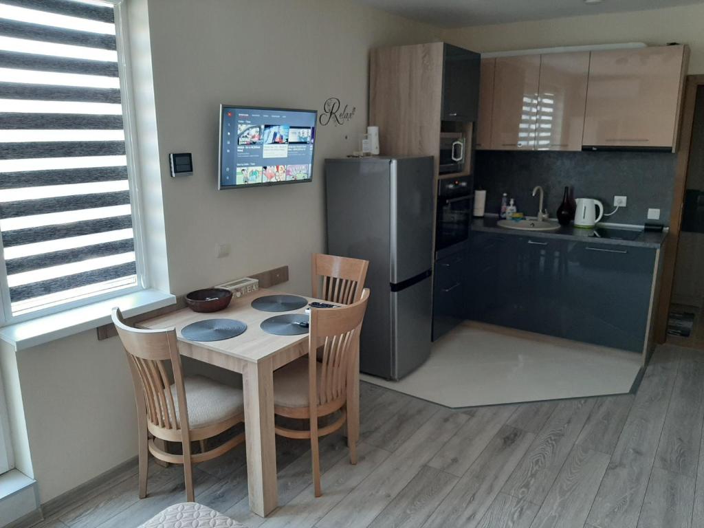 uma cozinha com uma mesa e cadeiras e um frigorífico em Apartment RELAX em Ruse