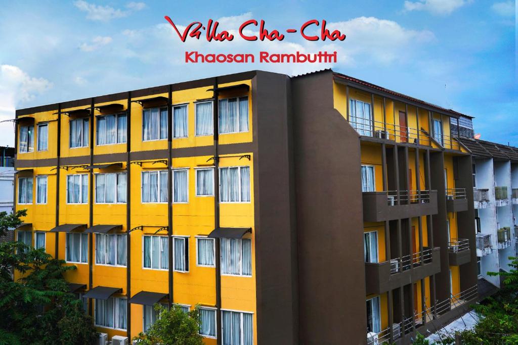 a yellow building in front of a building at Villa Cha-Cha Khaosan Rambuttri in Bangkok