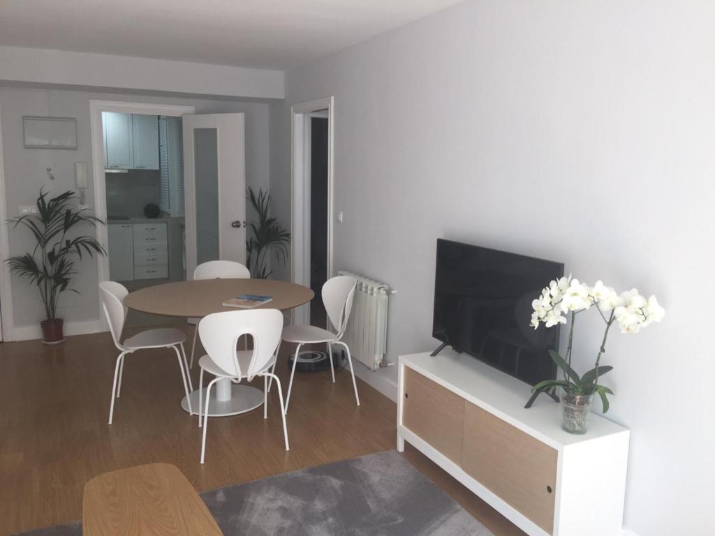uma sala de estar com uma mesa e uma televisão em Apartamento de La Luz Céntrico en Náutico -Parking em Vigo