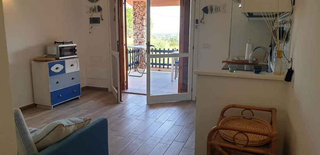un soggiorno con cucina e una porta che conduce a un balcone. di Residence Porto Rotondo a Porto Rotondo