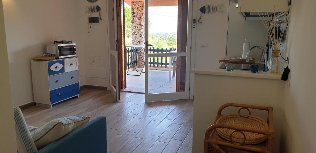 a living room with a kitchen and a door to a balcony at Residence Porto Rotondo in Porto Rotondo