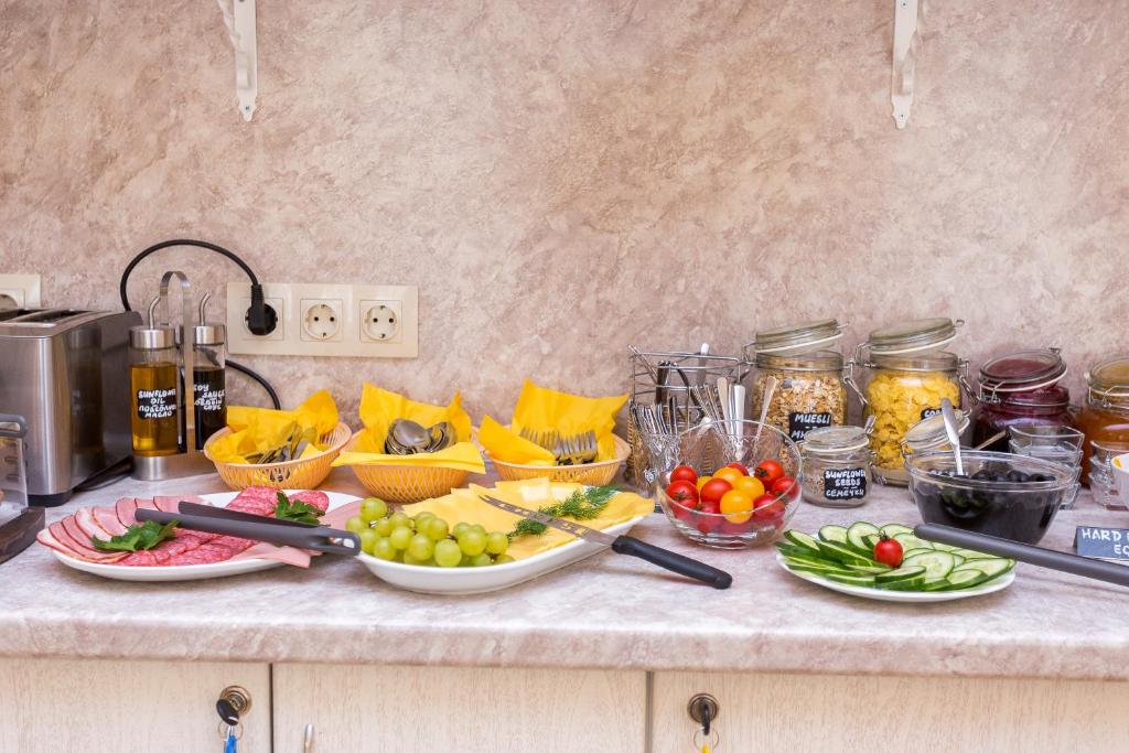 a counter with bowls of fruit and vegetables on it at Casa Leto in Saint Petersburg
