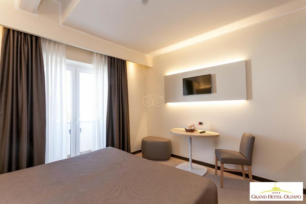 Postel nebo postele na pokoji v ubytování Grand Hotel Olimpo