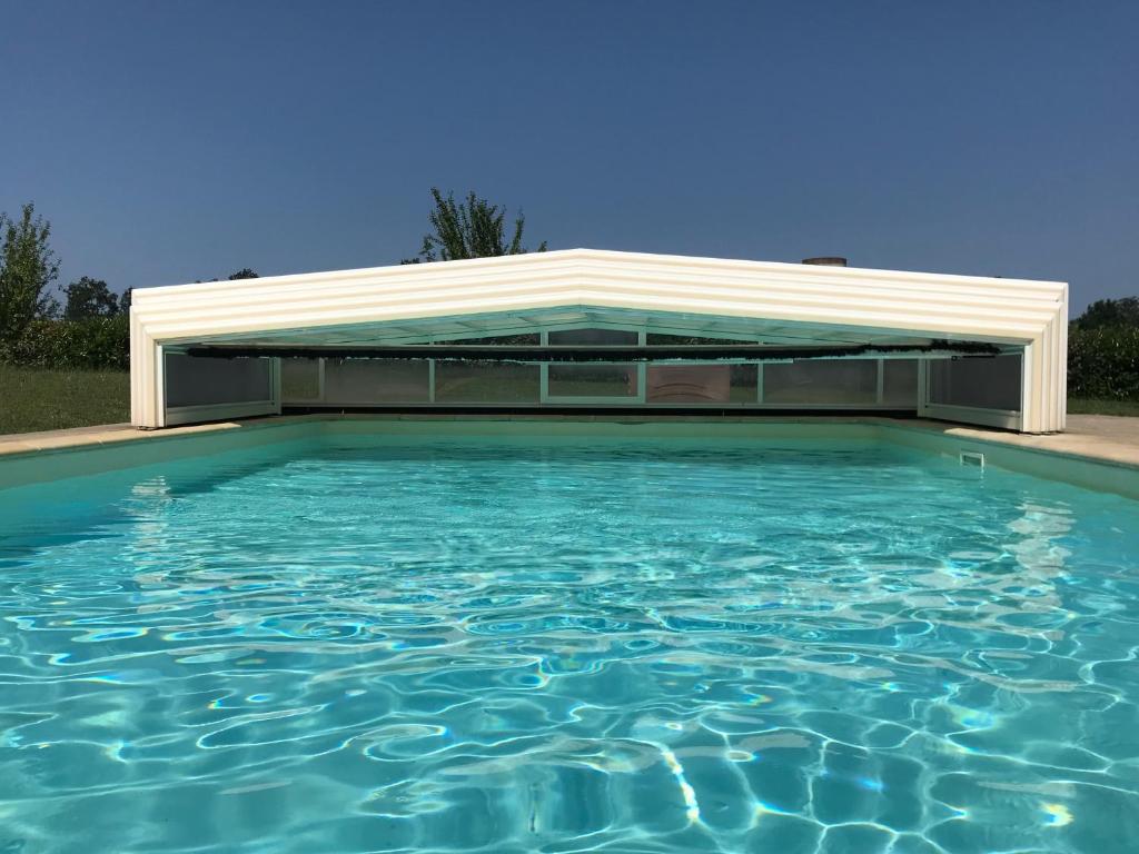 una piscina con un edificio detrás en La Banne Nord, en Cendrieux